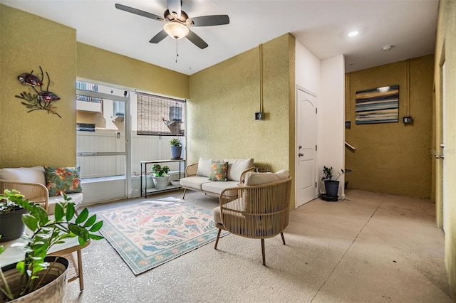 living area with concrete flooring and a ceiling fan