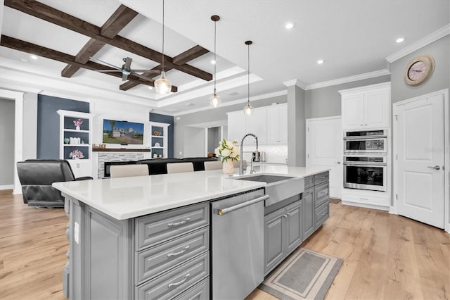 kitchen with a sink, appliances with stainless steel finishes, gray cabinets, and white cabinetry