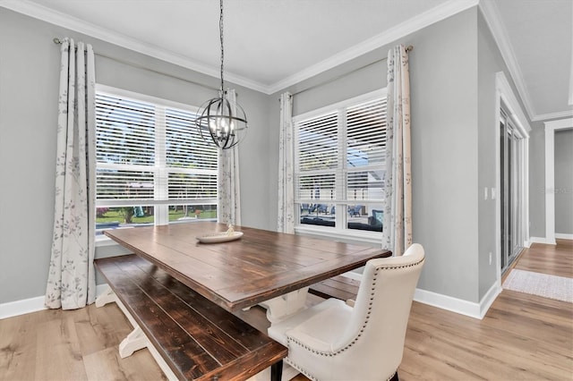 dining space with light wood-style flooring, baseboards, an inviting chandelier, and ornamental molding