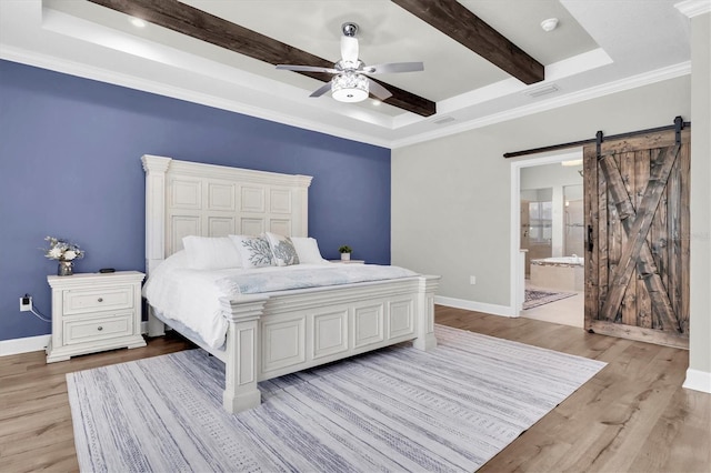 bedroom with beam ceiling, baseboards, light wood-type flooring, and a barn door