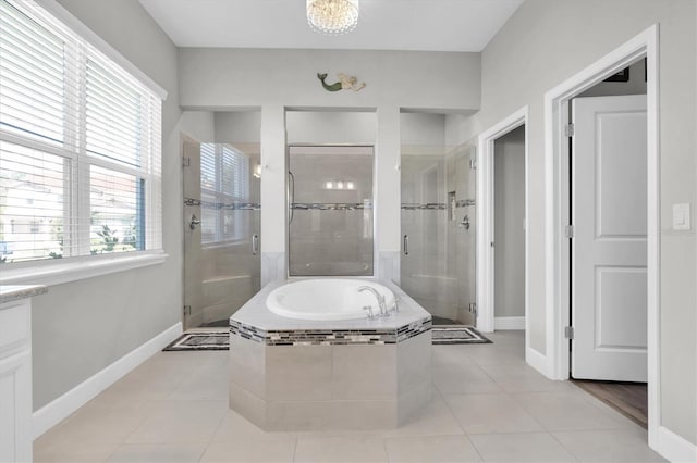 bathroom featuring tile patterned flooring, a garden tub, baseboards, and a stall shower