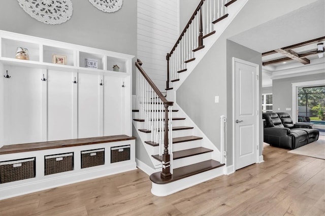 mudroom with beamed ceiling, light wood-style floors, baseboards, and coffered ceiling