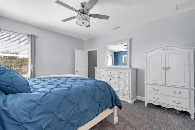 bedroom featuring multiple windows, visible vents, and dark carpet