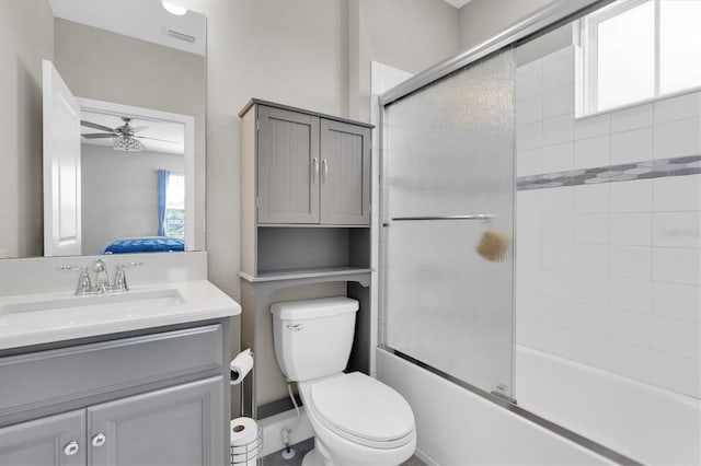 bathroom with visible vents, ceiling fan, toilet, combined bath / shower with glass door, and vanity