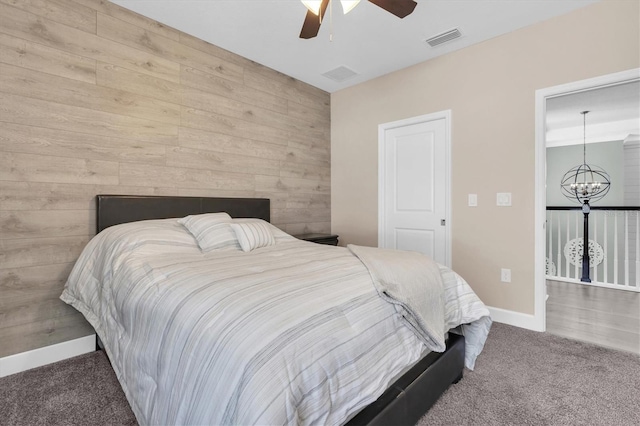 bedroom featuring visible vents, ceiling fan with notable chandelier, baseboards, and carpet