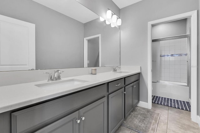 bathroom with tile patterned floors, double vanity, baseboards, and a sink