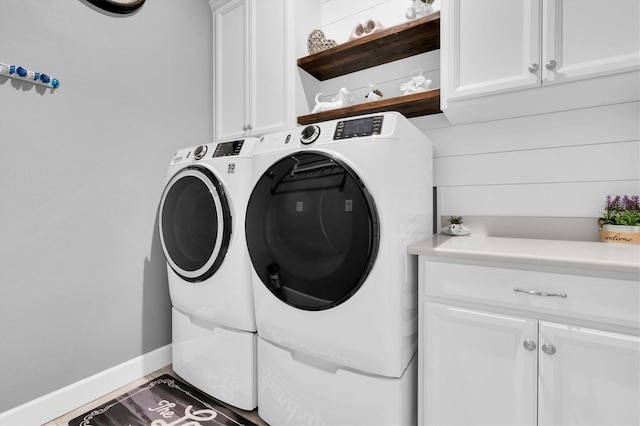 laundry area with washer and dryer, baseboards, and cabinet space