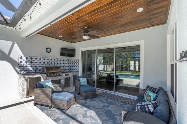 view of patio / terrace with an outdoor living space, area for grilling, a ceiling fan, and an outdoor kitchen