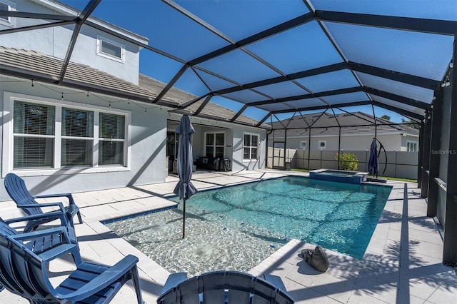 view of pool featuring glass enclosure, a patio, fence, and a pool with connected hot tub