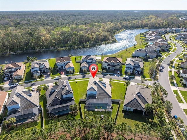 aerial view with a residential view, a wooded view, and a water view