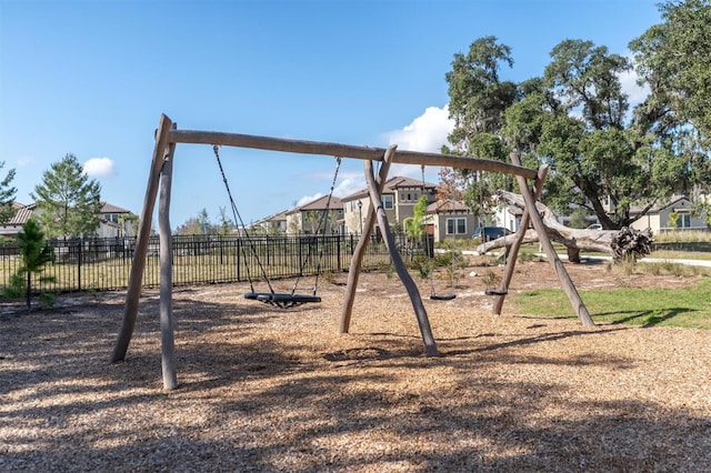 community jungle gym with a residential view and fence