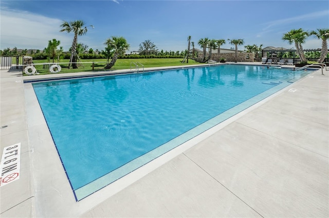 community pool featuring a patio and a lawn