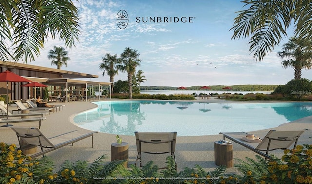 community pool with a water view and a patio area