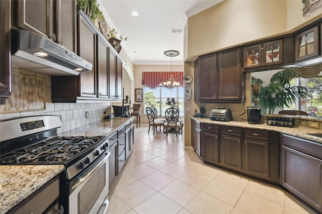 kitchen featuring dark brown cabinetry, under cabinet range hood, stainless steel gas range oven, crown molding, and a chandelier