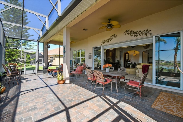 view of patio / terrace with outdoor dining space, a lanai, visible vents, and ceiling fan