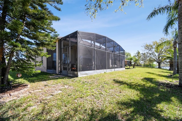 back of house featuring a lawn and a lanai