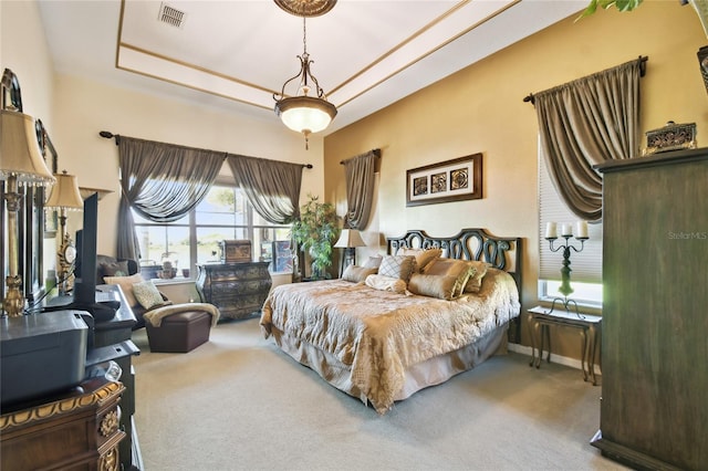 carpeted bedroom featuring visible vents, baseboards, and a tray ceiling