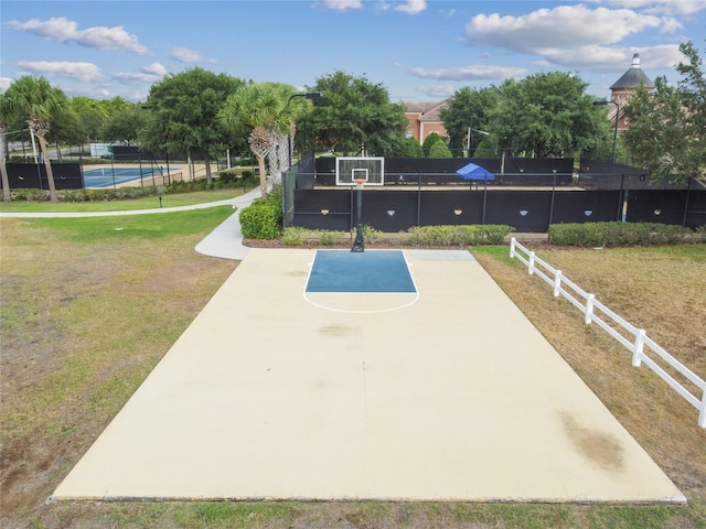 view of sport court featuring community basketball court, a lawn, and fence