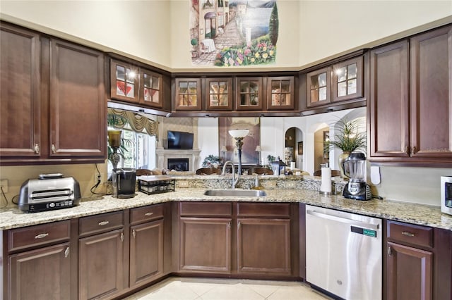 252 Bayou Bend Rd, Groveland, FL 34736 - kitchen with light stone countertops, dishwasher, a fireplace, a peninsula, and a sink