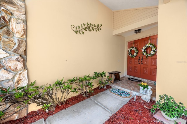 doorway to property with stucco siding and stone siding