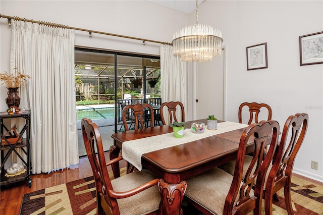 dining area featuring baseboards, an inviting chandelier, and wood finished floors