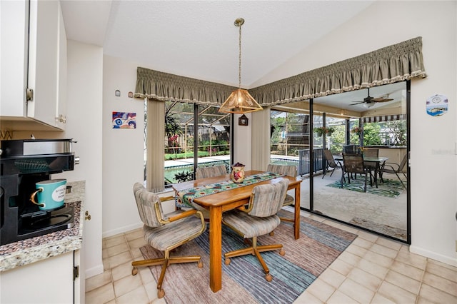 dining area featuring baseboards, ceiling fan, lofted ceiling, light tile patterned floors, and a textured ceiling