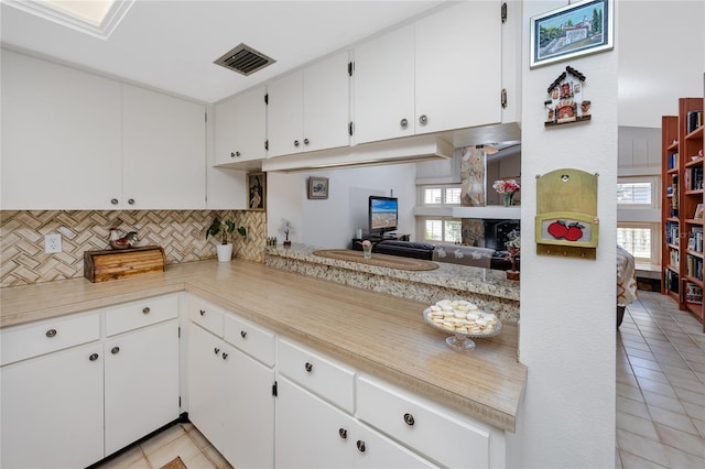 kitchen featuring decorative backsplash, light countertops, visible vents, and a wealth of natural light