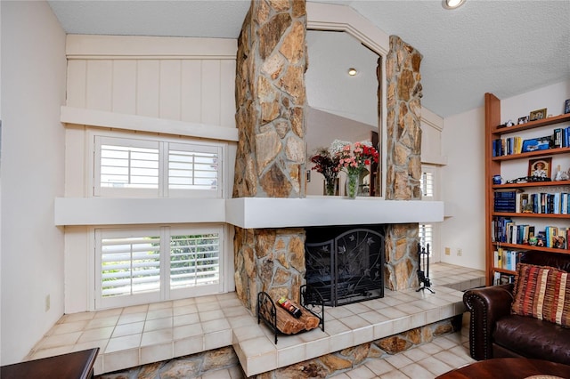 living area featuring a stone fireplace, high vaulted ceiling, a wealth of natural light, and a textured ceiling