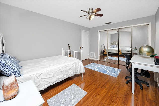 bedroom with a closet, visible vents, and wood finished floors