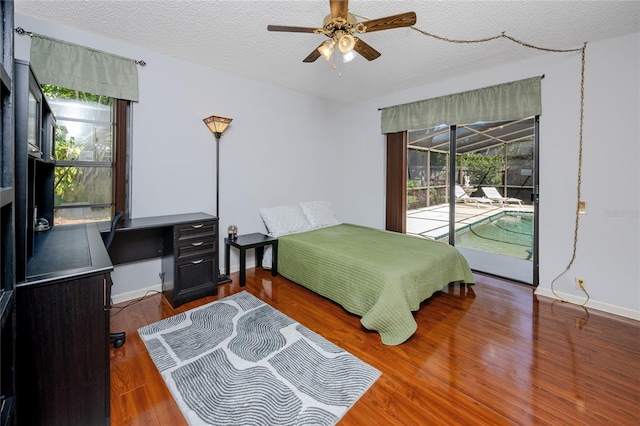 bedroom with access to outside, a textured ceiling, wood finished floors, baseboards, and ceiling fan