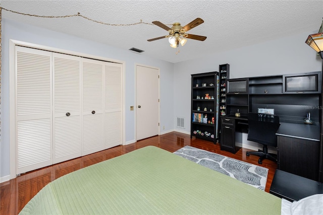 bedroom featuring visible vents, a textured ceiling, a closet, and wood finished floors