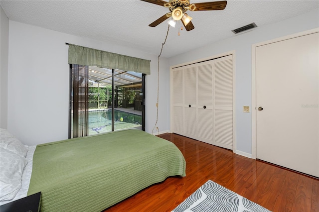 bedroom with visible vents, a textured ceiling, wood finished floors, and access to outside