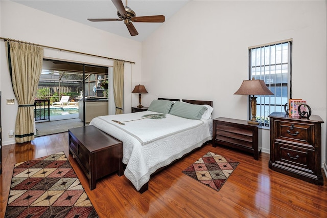 bedroom featuring wood finished floors, baseboards, multiple windows, and access to exterior