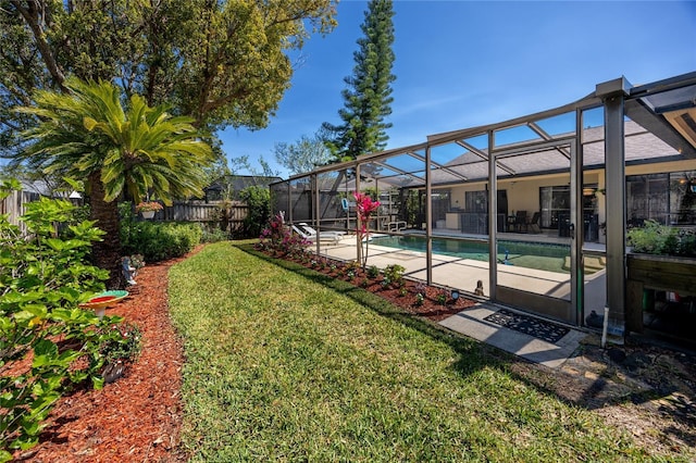 view of yard with glass enclosure, a patio area, fence, and a fenced in pool