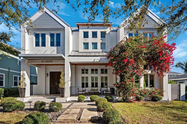 back of property with a porch and stucco siding