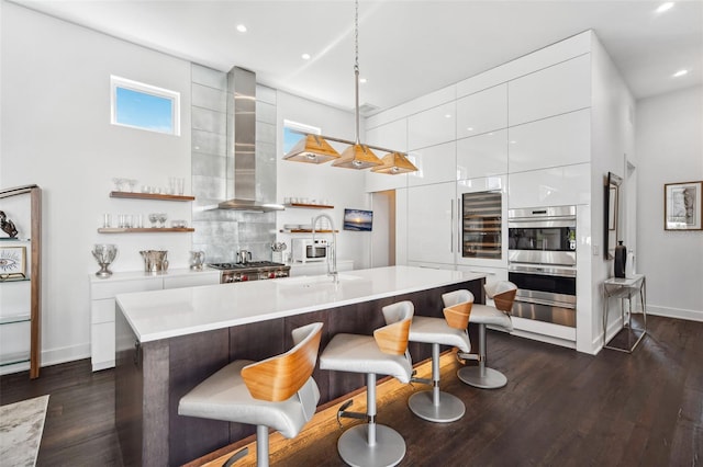 kitchen with modern cabinets, wall chimney exhaust hood, light countertops, and white cabinetry