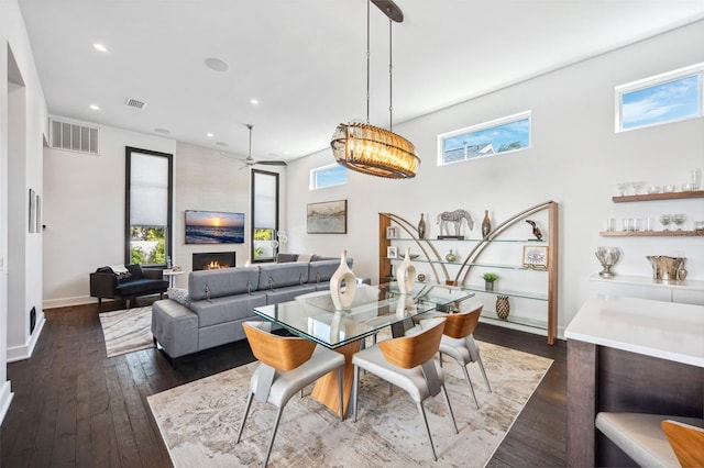 dining room with dark wood-style floors, visible vents, and plenty of natural light