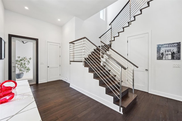 foyer entrance featuring stairway, baseboards, and wood finished floors