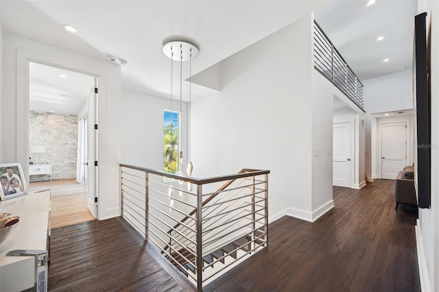 hall featuring recessed lighting, baseboards, an upstairs landing, and dark wood-type flooring