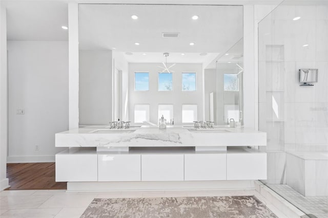 full bathroom with visible vents, double vanity, recessed lighting, a shower, and a sink