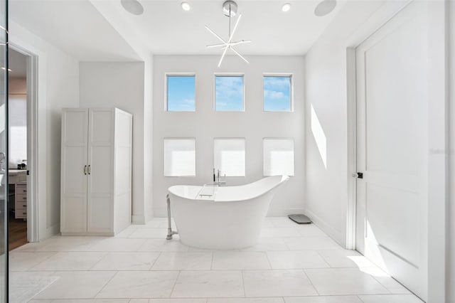 full bath featuring a freestanding tub and baseboards