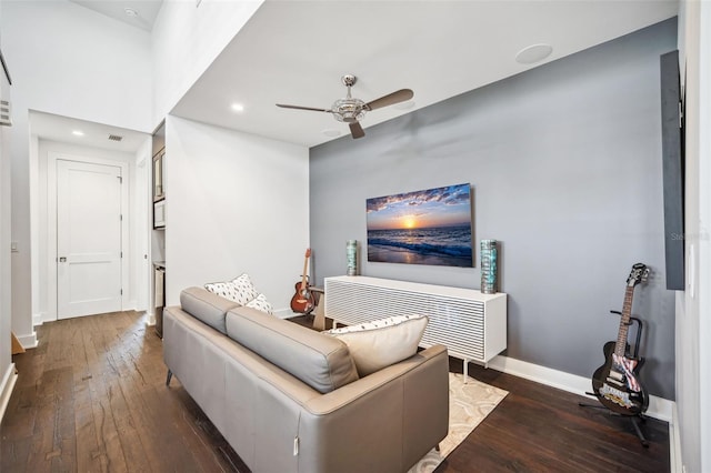 living area with a ceiling fan, visible vents, dark wood-style floors, and baseboards