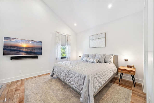 bedroom featuring recessed lighting, wood finished floors, baseboards, and high vaulted ceiling