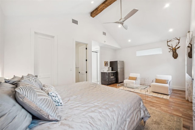 bedroom with visible vents, light wood-style floors, beamed ceiling, and freestanding refrigerator