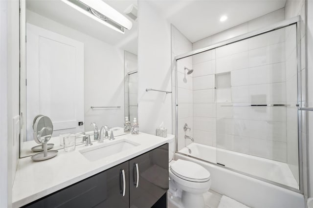 bathroom with combined bath / shower with glass door, toilet, and vanity