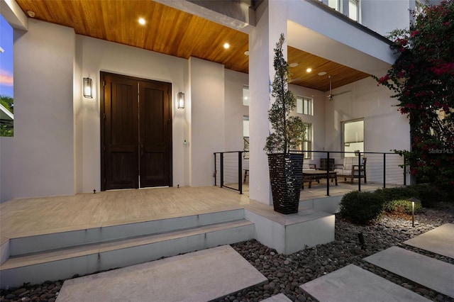 property entrance with a porch and stucco siding