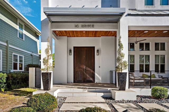 doorway to property featuring stucco siding and a porch