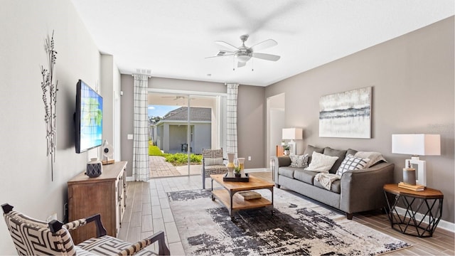 living room with ceiling fan, visible vents, baseboards, and wood tiled floor