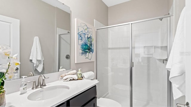 bathroom with vanity, toilet, and a stall shower