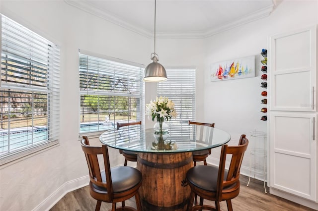 dining space with crown molding, baseboards, and dark wood-style flooring